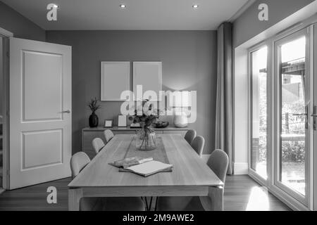 selected focus on glass vase and flowers monochrome black and white contemporary living didng room lifestyle layout with furniture  and soft furnishin Stock Photo