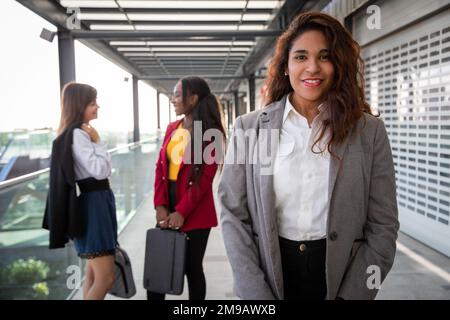 Portrait of a latina businesswoman with her colleagues behind her having a conversation Stock Photo