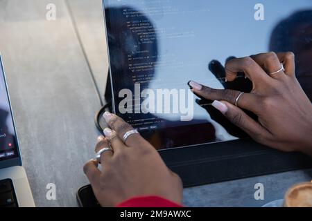 African female programmer writes some code on her tablet Stock Photo