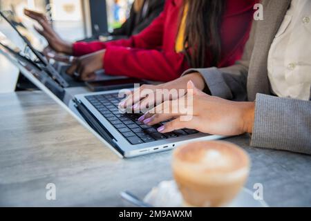 Close up of female hands working using laptops and tablets in the office, female workers Stock Photo