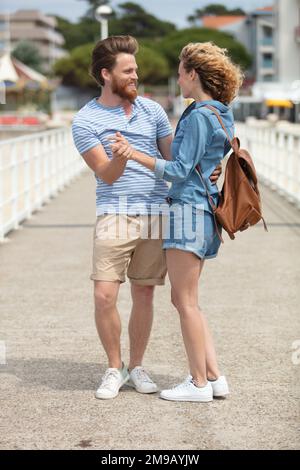 loving young couple dancing on pier at sunset in summer Stock Photo