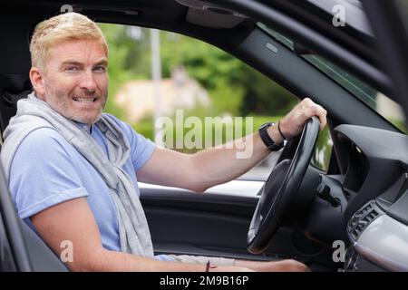 portrait of middle aged male driver behind the wheel Stock Photo