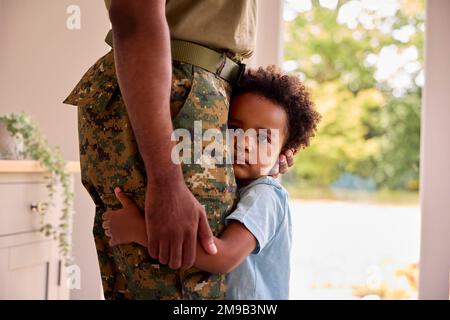 Close Up Of Loving Son Hugging Army Father In Uniform Home On Leave Stock Photo