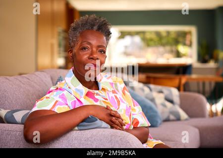 Portrait Of Retired Serious Senior Woman Sitting On Sofa At Home Stock Photo