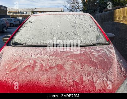 Motor car covered in a hard frost with frost patterns on bonnet and window Stock Photo