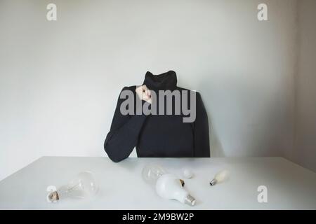 headless surreal person looks for the right light bulb for the most creative idea, concept of creativity, business, ideas, innovation Stock Photo