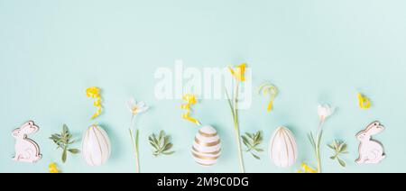 Festive Easter border, frame from easter eggs and spring flower crocus on blue background. Stock Photo