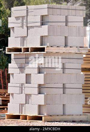 A pile of new bricks at construction site sitting on wooden flat Stock ...