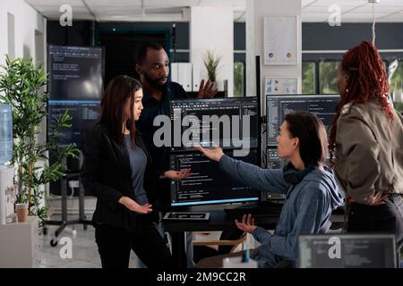 Multi ethnic web developers writing script while talking about develop cloud computing server. IT engineers having unexpected server error and no access to database, hacking attack. Stock Photo