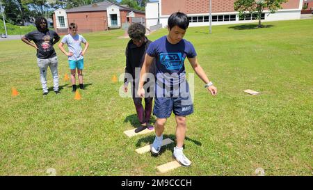 220516-N-LY580-1011 ALEXANDER CITY, Ala. (May 16, 2022) Benjamin Russell High School Navy Junior Reserve Officers Training Corps Cadets (front-back) Dylan Pham, Deandrea Salter, Tyler Sims and Jermaine Floyd develop teamwork through an exercise using wooden boards to move from station-to-station. BRHS,Benjamin Russell,NETC,NJROTC,NSTC, Stock Photo