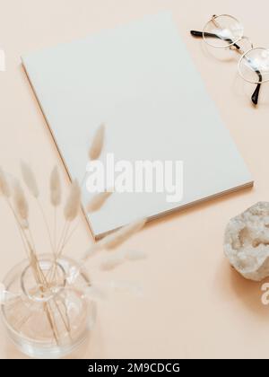Empty blank white magazine or catalog cover layout, vase, gkasses and white crystal on beige background. Flat lay. Top view. Copy space Stock Photo