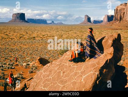 1950s TWO YOUNG NATIVE AMERICAN NAVAJO WRAPPED IN BLANKETS SIT ON SANDSTONE BOULDER LOOKING OUT ON SHEEP HERDERS MONUMENT VALLEY - kr9961 LAN001 HARS BALANCE LIFESTYLE FEMALES VALLEY RURAL HOME LIFE NATURE UNITED STATES COPY SPACE FRIENDSHIP FULL-LENGTH HALF-LENGTH SHEEP PERSONS SCENIC INSPIRATION TRADITIONAL SIT INDIANS UNITED STATES OF AMERICA MALES NAVAJO SPIRITUALITY CONFIDENCE MONUMENT NORTH AMERICA NORTH AMERICAN MAMMALS HIGH ANGLE BLANKETS FORMATIONS NAVAHO BUTTES ARIZONA BUTTE NAVAJO NATION RESERVATION GEOLOGIC NATIVE AMERICAN HARMONY HERD MAMMAL NATIVE AMERICANS NEW MEXICO PRE-TEEN Stock Photo