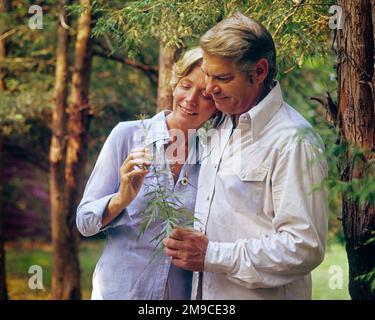 1970s MATURE COUPLE ROMANTIC POSE IN THE FOREST HOLDING A SMALL GREEN LEAFY BRANCH - ks11775 PHT001 HARS PEACE EMBRACE STRONG PLEASED JOY LIFESTYLE FEMALES FOREST MARRIED BRANCH RURAL SPOUSE HUSBANDS NATURE COPY SPACE FRIENDSHIP HALF-LENGTH HUG LADIES PERSONS INSPIRATION CARING MALES SERENITY CONFIDENCE EMBRACING MIDDLE-AGED PARTNER MIDDLE-AGED MAN HAPPINESS MIDDLE-AGED WOMAN CHEERFUL LEISURE RELATIONSHIPS SMILES CONNECTION JOYFUL STYLISH LEAFY PERSONAL ATTACHMENT AFFECTION EMOTION GROWTH POSE TOGETHERNESS WIVES CASUAL CAUCASIAN ETHNICITY OLD FASHIONED Stock Photo