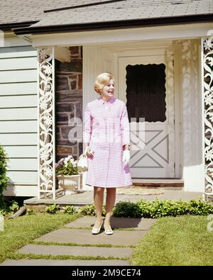 1960s BLOND WOMAN WEARING LAVENDER & WHITE CHECKED DRESS WHITE SHOES GLOVES PURSE SMILING STANDING SIDEWALK IN FRONT OF HOUSE - ks5175 HAR001 HARS LIFESTYLE SATISFACTION ARCHITECTURE FEMALES HOUSES HEALTHINESS HOME LIFE COPY SPACE FULL-LENGTH LADIES PERSONS RESIDENTIAL BUILDINGS CONFIDENCE LAVENDER SUMMERTIME HAPPINESS CHEERFUL PROPERTY STYLES CHECKED EXTERIOR HAIRSTYLE PRIDE HOMES SMILES REAL ESTATE STRUCTURES JOYFUL RESIDENCE STYLISH SUNDAY BEST EDIFICE FRONT DOOR IN FRONT OF DRESSED UP FASHIONS MID-ADULT MID-ADULT WOMAN TEASED & CAUCASIAN ETHNICITY HAR001 OLD FASHIONED Stock Photo