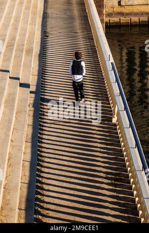 Young boy skipping happily along sunlit stone path; Fairmount Water Works; Philadelphia; Pennsylvania; USA Stock Photo