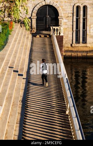 Young boy skipping happily along sunlit stone path; Fairmount Water Works; Philadelphia; Pennsylvania; USA Stock Photo