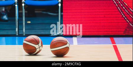 Two basketball balls laying on the floor in the gymnasium. Sport concept. High quality photo Stock Photo