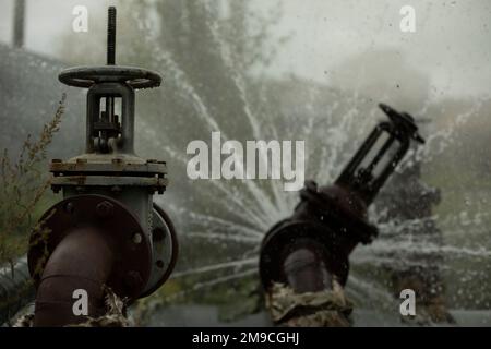 Breakthrough heating pipe. Pipeline accident. Boiling water pours out. Stock Photo