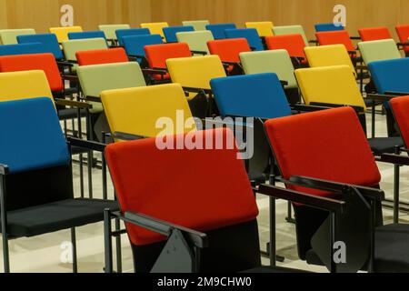 Straight rows of colourful chairs in the hall Stock Photo