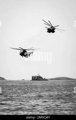 220516-N-PC065-1049   SKYROS ISLAND, Greece (May 16, 2022) – Two U.S. Marine Corps CH-53E Super Stallion helicopters, assigned to Marine Medium Tiltrotor Squadron (VMM) 263 (Rein.), deployed with the San Antonio-class amphibious transport dock ship USS Arlington (LPD 24), fly over a Greek (Hellenic) Zubr-class landing craft, air cushion, during joint training off the coast of Skyros Island, Greece, May 16, 2022. Arlington, with embarked 22nd Marine Expeditionary Unit, is participating in exercise Alexander the Great 2022 under the command and control of Task Force 61/2. Alexander the Great 22 Stock Photo