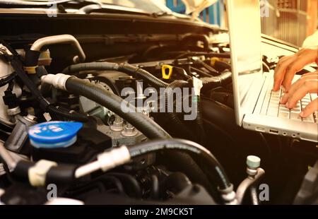Mechanic using Diagnostic machine tools for car. Equipment, Laptop, Stock Photo