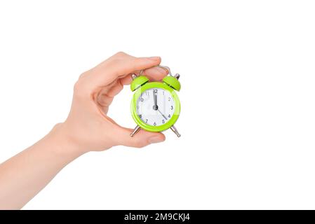 Hand holding a small alarm clock. The concept of time management. Green Alarm clock on a white background. Banner with copy space. Stock Photo