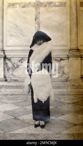 An elegant young woman in Venice wearing an amazing white fur stole. Stock Photo
