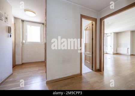 Entrance hall with armored door and distributor of an empty house with access to several rooms and oak doors Stock Photo
