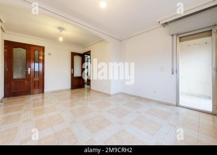 Empty living room with white walls and stoneware floor with a corner terrace and sapele wood double access doors Stock Photo