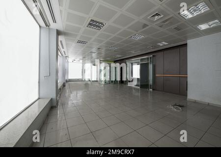 Local with a large room without partitions with the perimeter full of translucent windows Stock Photo