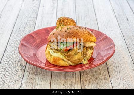 A wonderful sandwich with shredded meat stew, dehydrated tomato and lettuce Stock Photo
