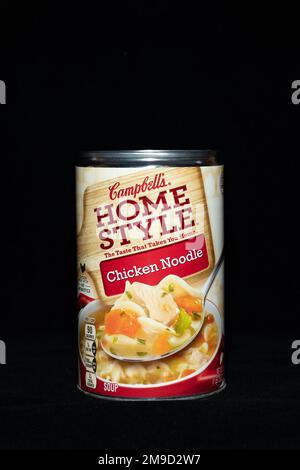 A can of Campbell's Home Style Chicken Noodle soup, a meal that just needs heating, isolated on black Stock Photo