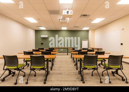 Interior of an office training, meeting, conference room with desks, chairs, and white board.  Nobody included in image. Stock Photo