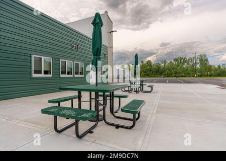 Picnic tables with umbrellas at a corporate office outdoor dining area Stock Photo