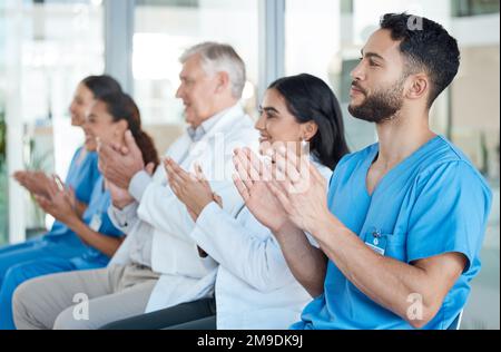 Making great strides in medicine. a team of medical staff applauding during a conference. Stock Photo