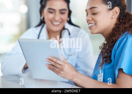 Will you send that to me. two female medical professionals having a meeting together while using a digital tablet. Stock Photo