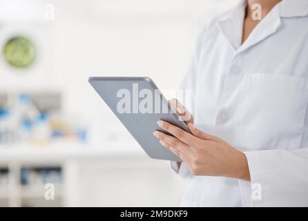 Navigating the latest case. Closeup shot of an unrecognisable scientist using a digital tablet in a lab. Stock Photo