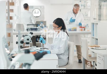 Analysing the sample extensively. a young scientist working with samples in a lab. Stock Photo