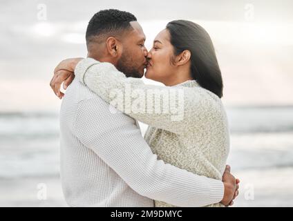 Still as passionate as ever. an affectionate young couple sharing an intimate moment on the beach. Stock Photo