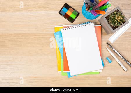 Back to school concept. Top view photo of notepads, pens, sharpeners, ruler, staplers, clips, markers and erasers on wooden table Stock Photo