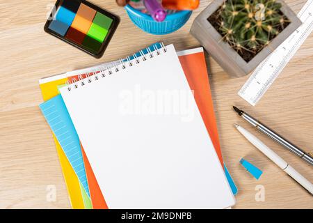 Back to school concept. Top view photo of notepads, pens, sharpeners, ruler, staplers, clips, markers and erasers on wooden table Stock Photo