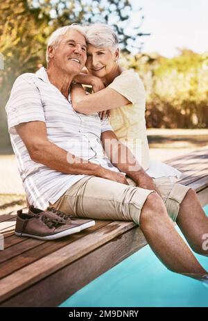 Senior couple, relax and smile for pool, love and summer vacation, bonding or quality time together in the outdoors. Happy elderly man and woman Stock Photo