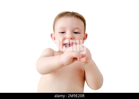 Child cleans his mouth with a toothbrush in his hands, isolated on a white background. Happy toddler baby learns to brush her teeth while lying on her Stock Photo