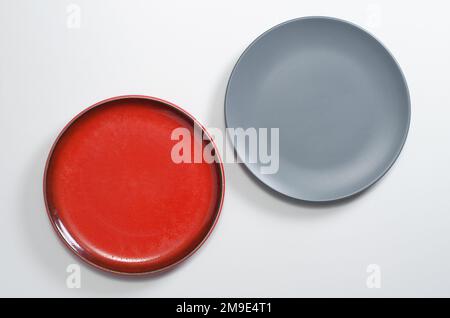 Red and gray empty plates on white table, top view Stock Photo