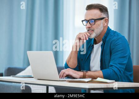 Working from home is the dream. a mature businessman working from home using his laptop. Stock Photo