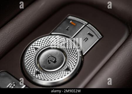 Side mirrors control panel on side door. Car driver adjust side mirror controller. Side mirror control button for adjusting the mirrors. Stock Photo
