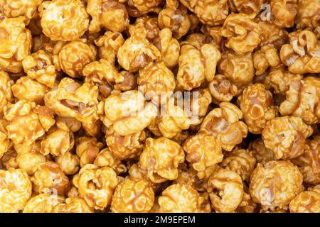 Caramel popcorn background texture. Popcorn pattern. Heap of delicious popcorn. Scattered popcorn texture background Stock Photo