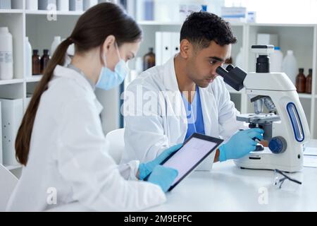 Theres lots to observe and record. two scientists working in a lab. Stock Photo