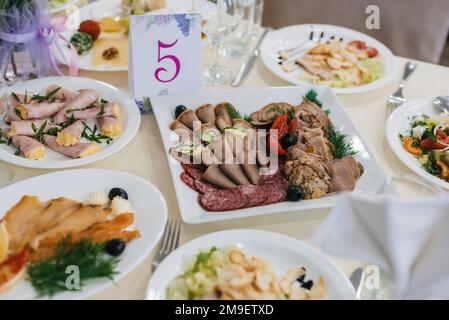 various meat snacks and salads on the festive table for dinner in the restaurant Stock Photo