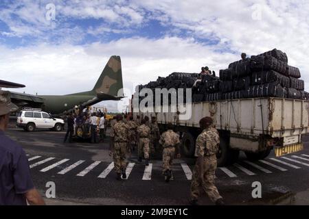 Medium shot. A Portugese Aircrew and local laborers load a vechicle and blankets onto a Portugese C-130 at the International Airport at Maputo, Mozambique, Africa, on 17 March 2000. The aircraft and its crew are deployed to Maputo in support of Operation Atlas Response, a Humanitarian Aid Operation to help the people of Mozambique, after severe flooding displaced over a million people from their homes. Medium shot.  A Portugese Aircrew and local laborers load a vechicle and blankets onto a Portugese C-130 at the International Airport at Maputo, Mozambique, Africa, on 17 March 2000.  The aircra Stock Photo